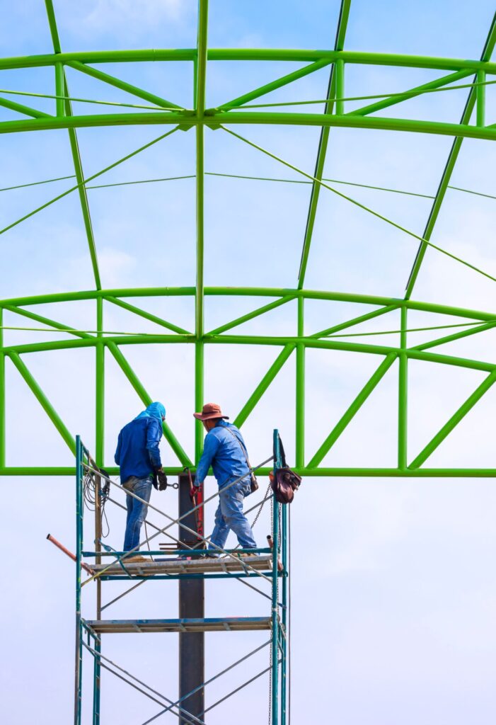 Foreman and construction worker working on scaffolding in construction site